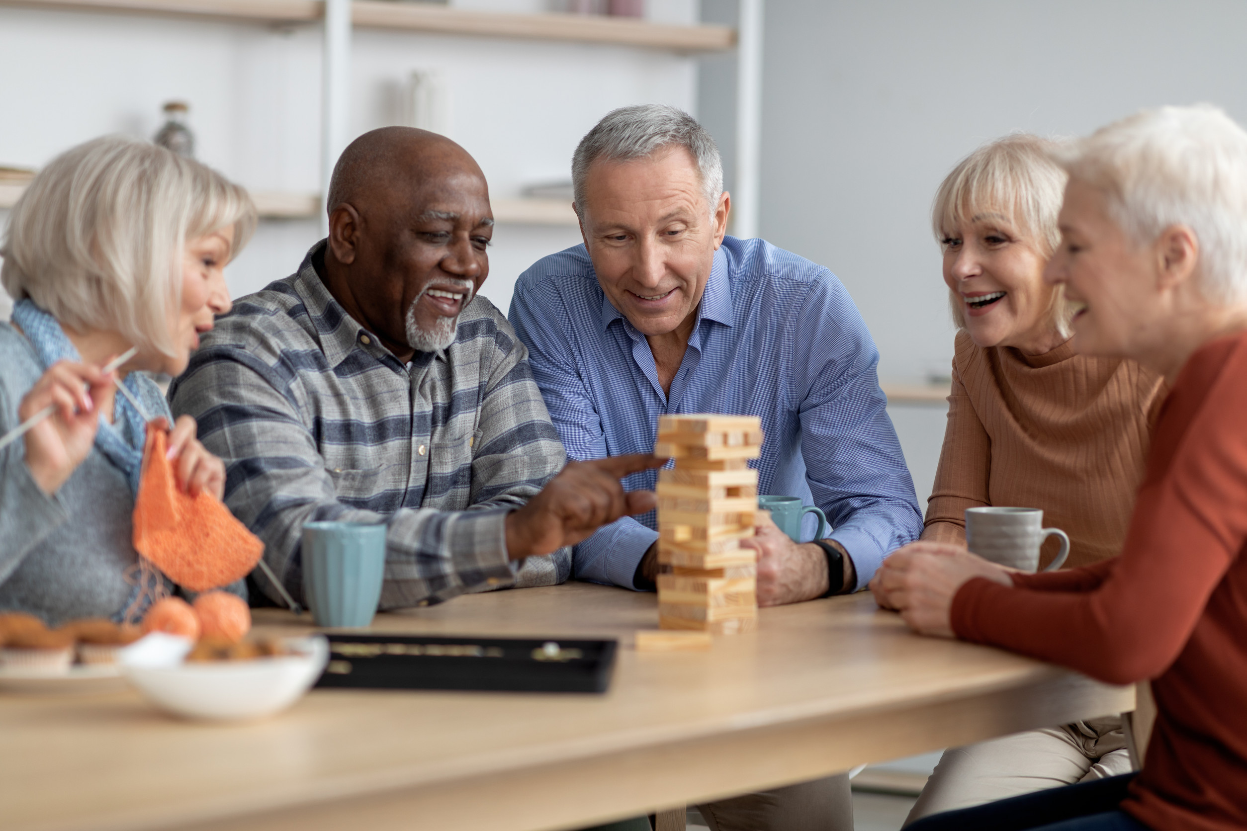 Emotional seniors playing jenga, having fun at sanatorium Emotional seniors playing jenga, having fun at sanatorium